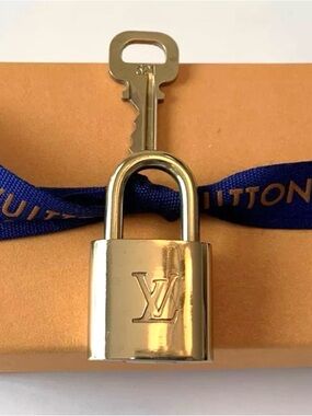 NEAR MINT AUTHENTIC Louis Vuitton lock and key set.